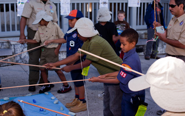 Children wearing Lancelot Jones-style fishing hats use simple poles to learn about being a fishing guide.