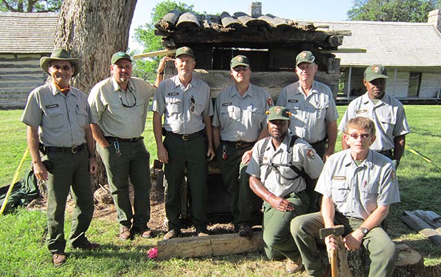 Participants in the Hands on Preservation Workshop stand with historic buildings in background