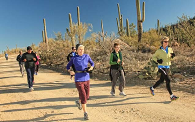 BEYOND participants running on a dirt road among the saguaro cactus in Saguaro National Park