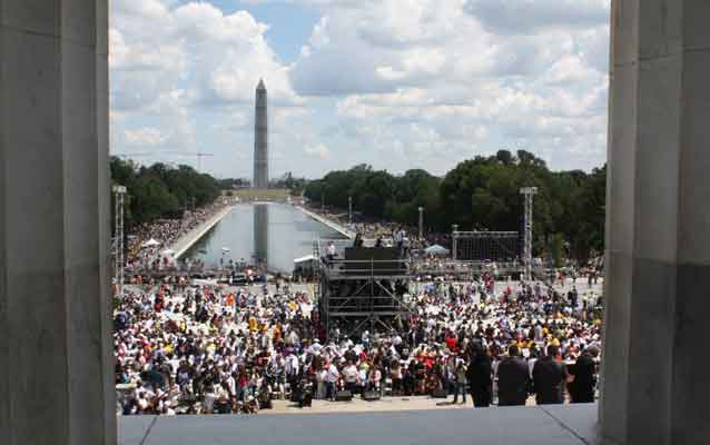 crowd stands on the lincoln memorial plaza with washington monument in the background
