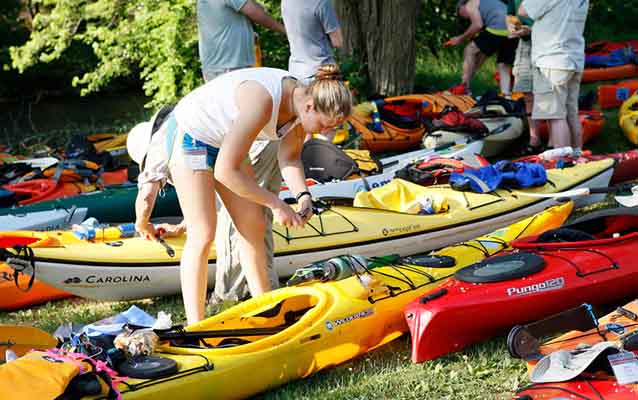 A young woman prepares her kayak for a day on the water.