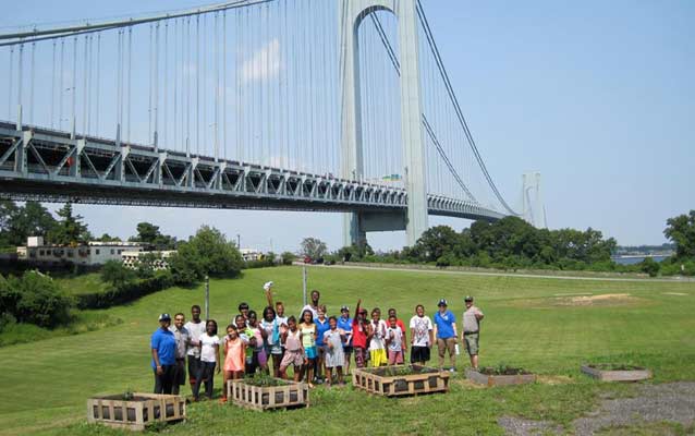 A group of students stand near the Verrazano bridge