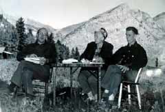 black and white image of three people at an outdoor table black and white image of three people at an outdoor table