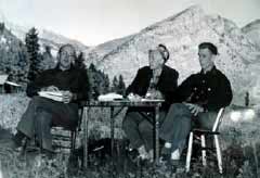 black and white image of three people at an outdoor table