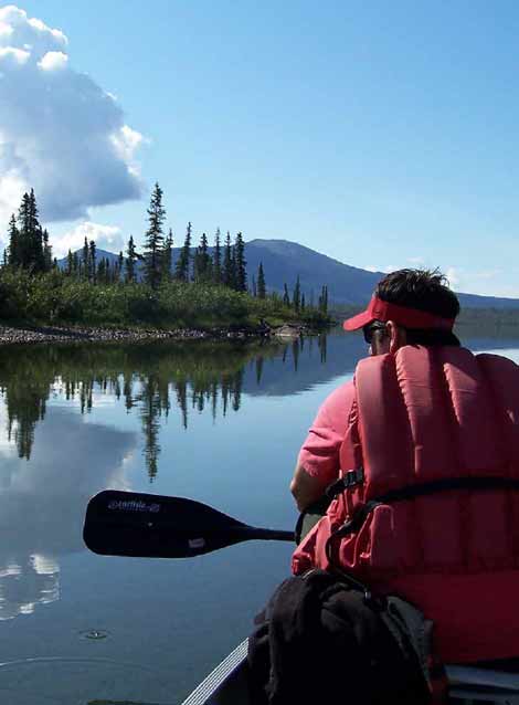 man sitting in a canoe on a lake