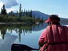 man sitting in a canoe on a calm lake