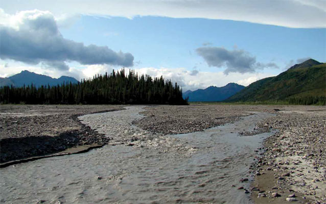 shallow river flowing across a gravel plain