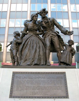 A bronze statue of two parents and two children and a plaque labeled 