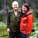 woman and older man standing in a forest