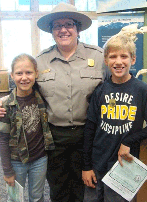 A ranger stands with two junior rangers A ranger stands with two junior rangers