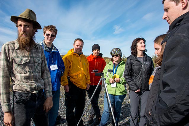 A group of students stand around a tripod