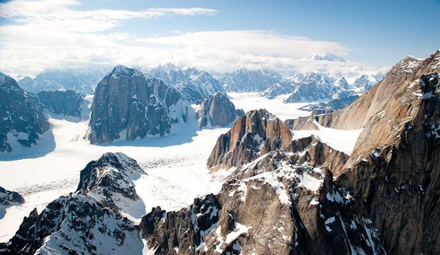 steep rocky mountains poking out from a vast ice field steep rocky mountains poking out from a vast ice field