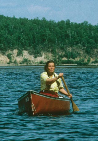 woman paddling a canoe on a lake