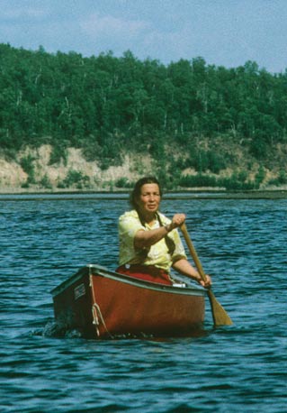 woman paddling a canoe on a lake woman paddling a canoe on a lake