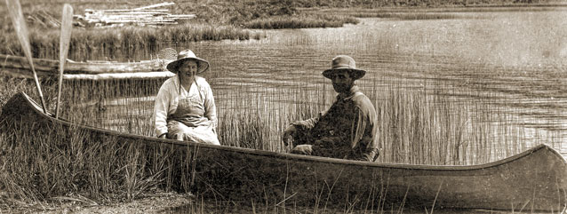 sepia toned image of a man and woman in a canoe