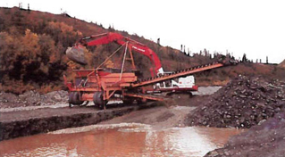 large machine scraping up earth and dumping it into a sluice large machine scraping up earth and dumping it into a sluice