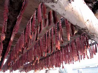 strips of salmon hanging from a ceiling rack