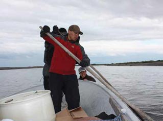 two men standing in a boat