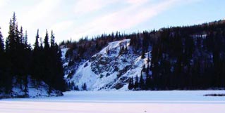 a snowy lake surrounded by hills and trees