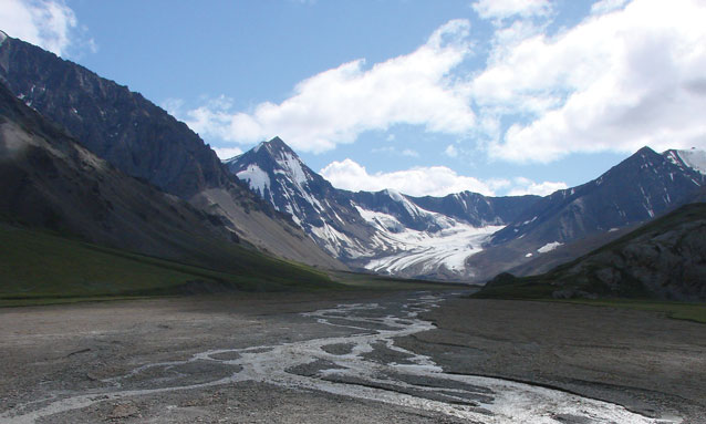 gravel lined river flowing down from steep mountains