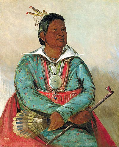 Man in elaborate green and red jacket with white collar, holding feathers and a ceremonial tomahawk