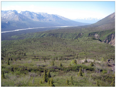 Rivers cut through a wide view of a valley stretched between mountain ridges.