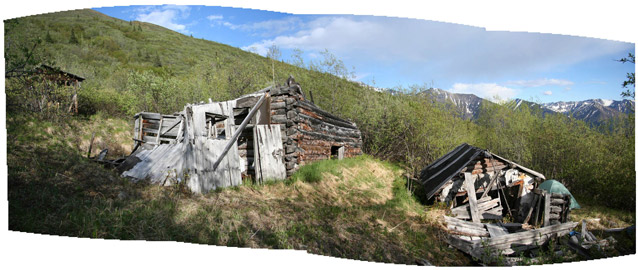 Dilapidated wooden structures are built on terraces in a mountainous landscape.