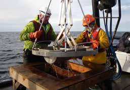 two men using equipment on a boat two men using equipment on a boat