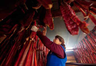woman in a room with numerous salmon hanging down from the ceiling woman in a room with numerous salmon hanging down from the ceiling