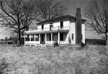 Porches extend across the length of both levels of a two-story house with white siding.