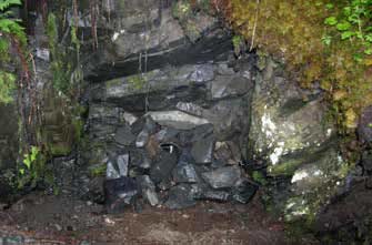 A mine opening covered by gray material A mine opening covered by gray material