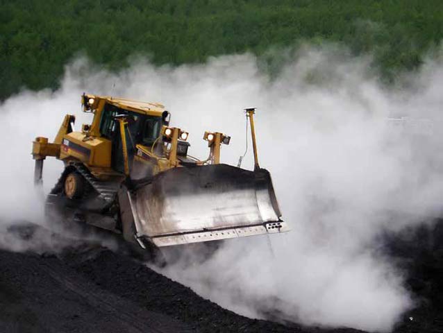 bulldozer driving through a smoking field