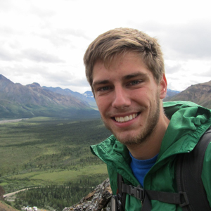 Researcher poses in a mountainous scene