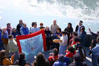 numerous people in a boat gathered around a blanket numerous people in a boat gathered around a blanket