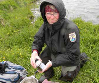 woman in rain gear kneeling on the ground