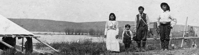 Family of four stands near lake Family of four stands near lake
