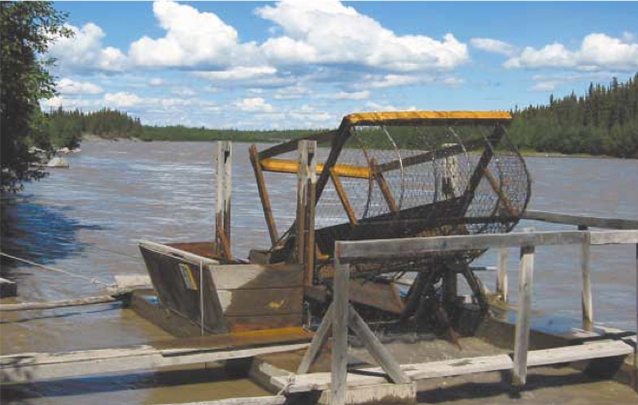 A fishwheel sits on the bank of the river A fishwheel sits on the bank of the river