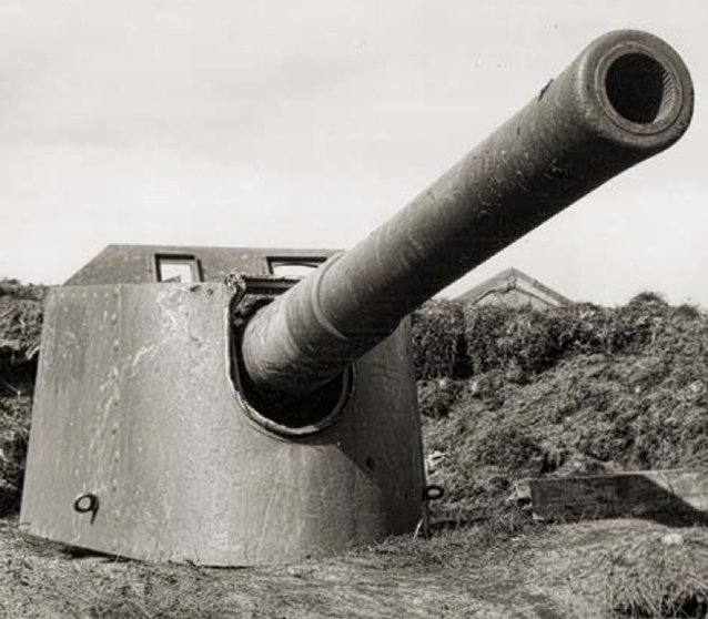 Front view of a large gun. Barrel extends across picture towards viewer.