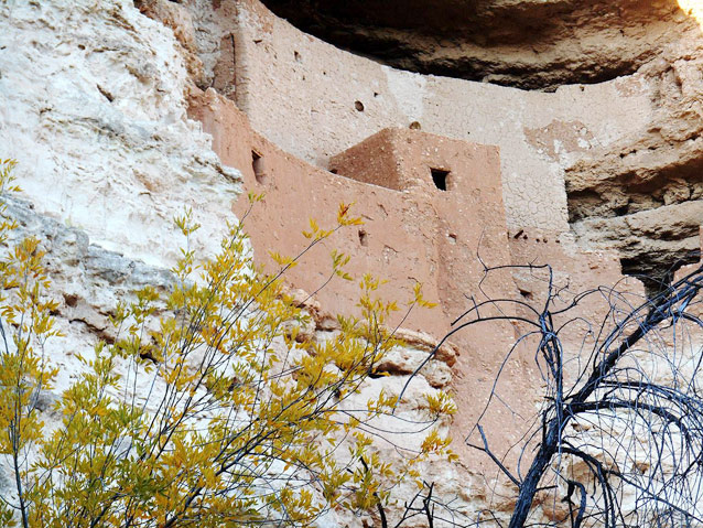 The outer walls and windows of a dwelling nestled into the face of  sheer cliff