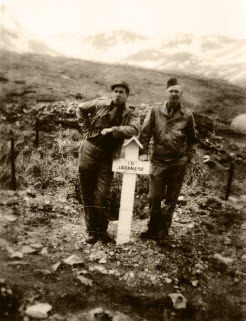 Two soldiers pose near a Japanese grave marker.