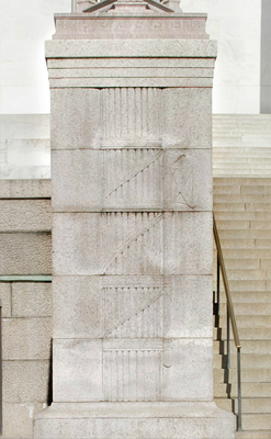 A carving of a bundle of rods on a stone wall