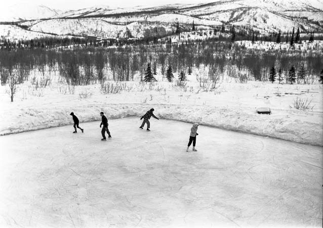 black and white image of four people skating on an ice rink black and white image of four people skating on an ice rink