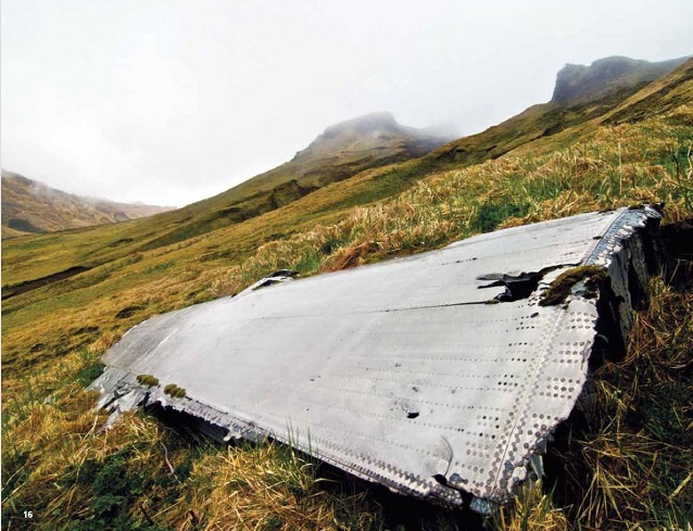 Metal airplane wing on a grassy hillside Metal airplane wing on a grassy hillside