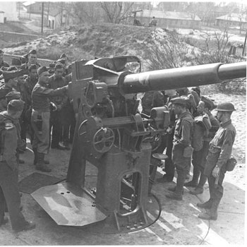 B&W photo of military men surrounding large gun