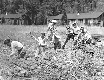 B&W; sailors in front of low buildings and hay pile B&W; sailors in front of low buildings and hay pile