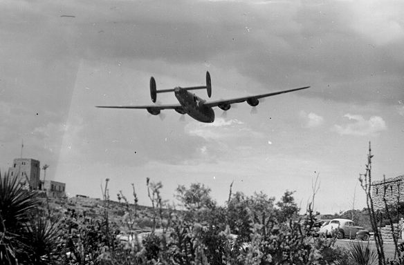 B&W photo of plane flying low over landscape