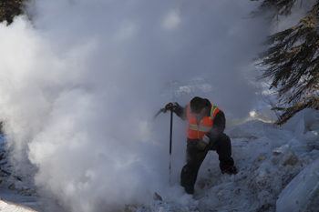 a road worker stands in a cloud of steam a road worker stands in a cloud of steam