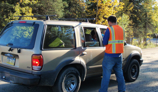 a researcher talks to visitors in a vehicle about their park visit