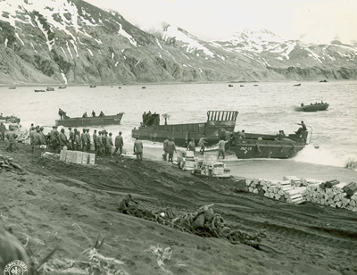 A crowd stands at the railing of a boat, looking into the distance.