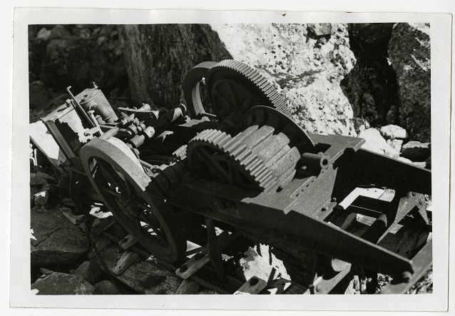 Black and white image of rusted metal item and rocks